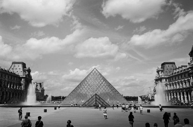 Louvre di Angelo Golizia: la piramide del museo parigino in bianco e nero, con visitatori nella piazza.