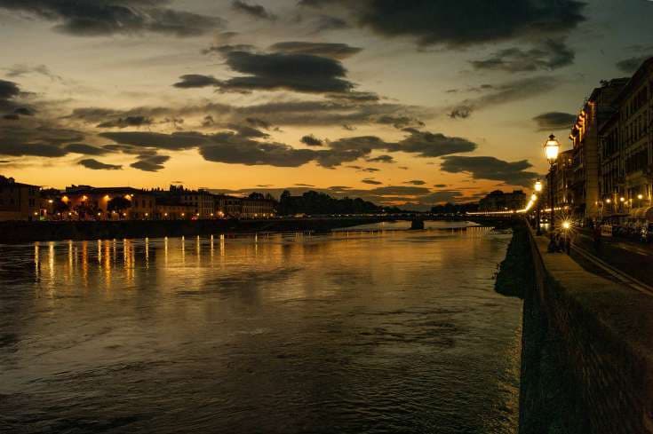 Florence di Angelo Golizia: l'Arno a Firenze al tramonto, con riflessi dorati e lampioni sul lungarno.